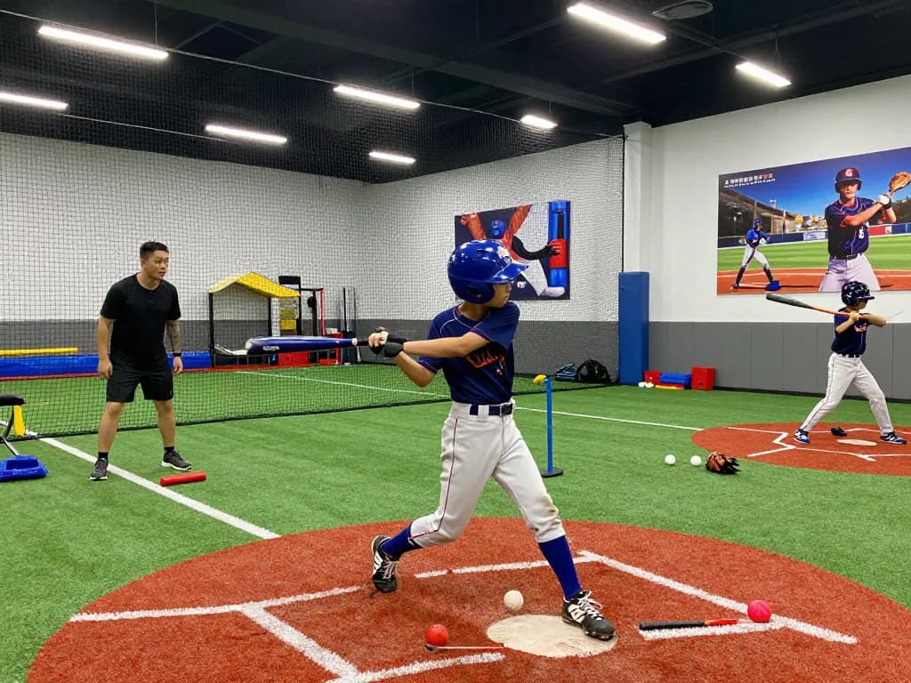 Young athlete training at HitClub baseball facility, focusing on swing techniques with coaching support in a dynamic environment.